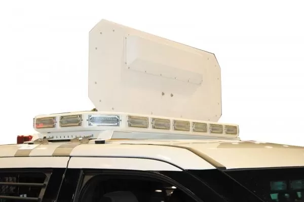 White rear face of the deployed panel standing above the roof-mounted LED bar on a marked SUV