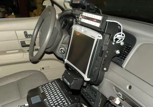 Control head mounted on the dash above a laptop and keyboard in an outfitted police cruiser