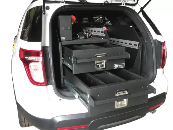 Both drawers pulled fully open at the tailgate of a white Ford utility, divided interiors visible