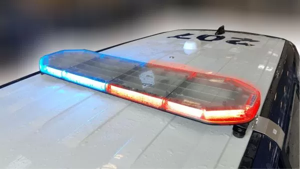 Three-quarter view on a white cruiser roof, blue at one end and red along the rest of the lens