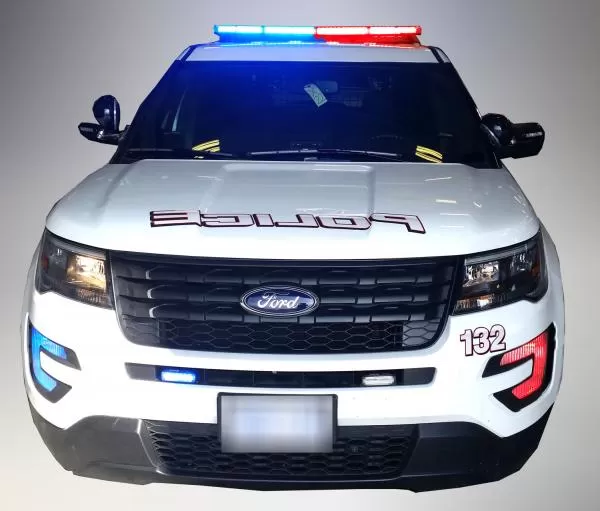 Front of a white Ford Explorer police unit with the roof bar, grille and bumper LEDs flashing