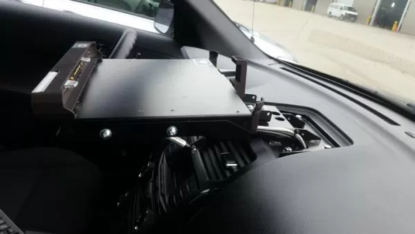 Close-up of the dash mount plate bolted to the passenger side of the dash with the dock body at left