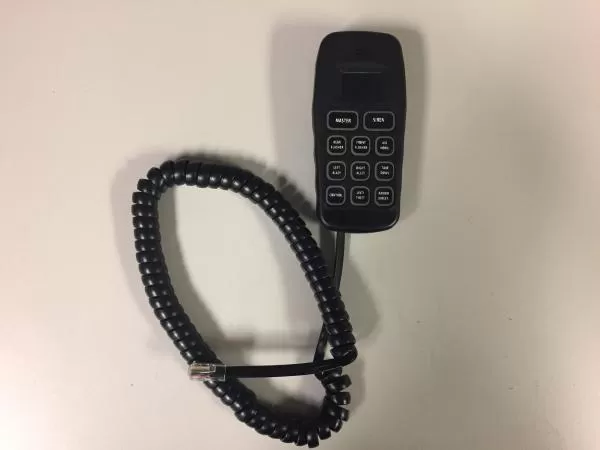 Handheld touchpad lying beside its coiled cord and modular plug on a bench