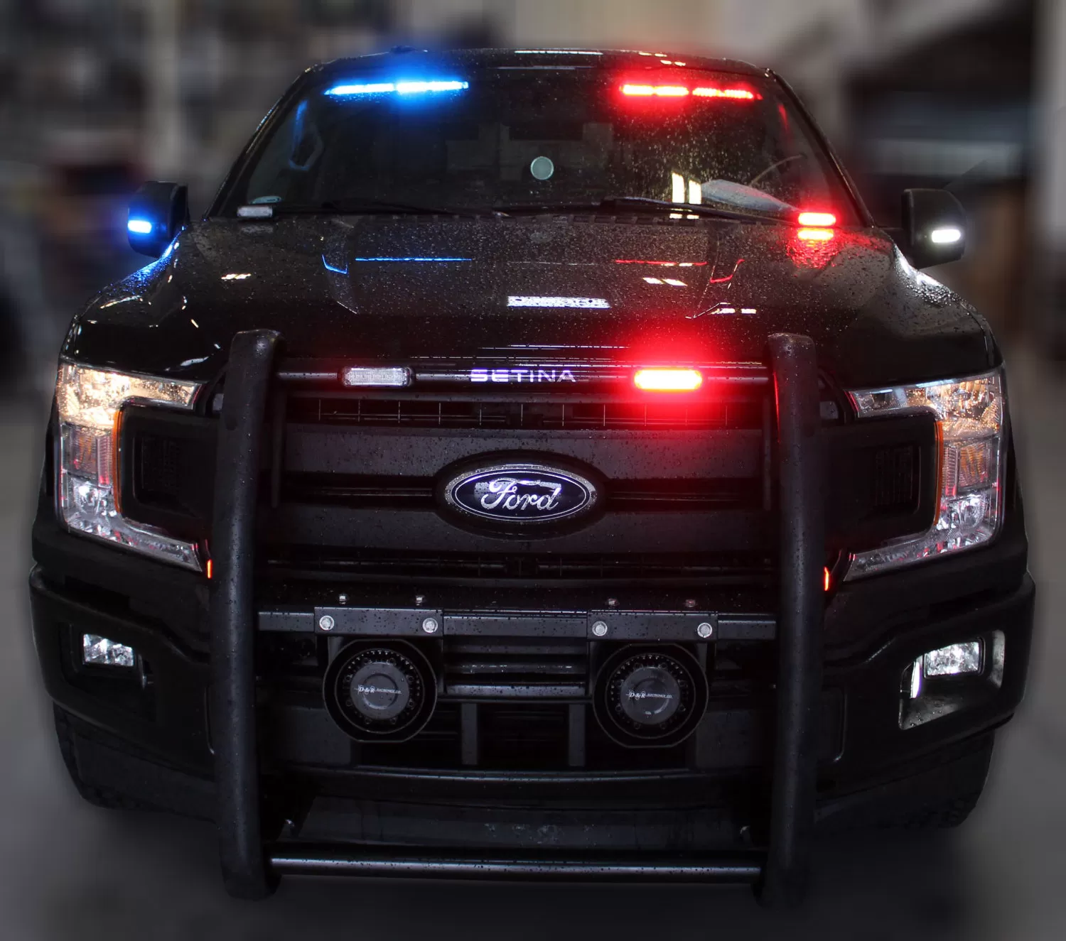 Black Ford F150 with push bumper, visor bar flashing blue on the left and red on the right