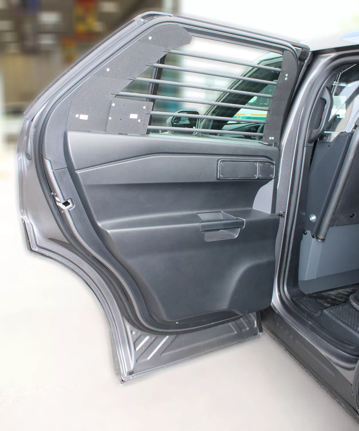Rear door open on a grey SUV with bars fitted across the door glass above the factory trim panel