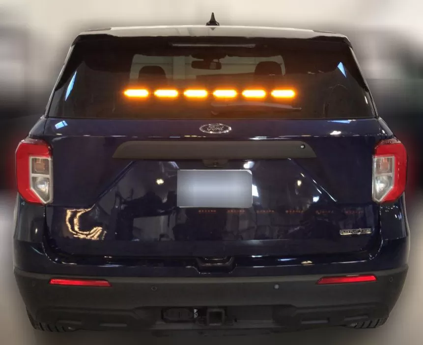 Dark Ford Explorer with all six rear-window modules lit steady amber in a straight line