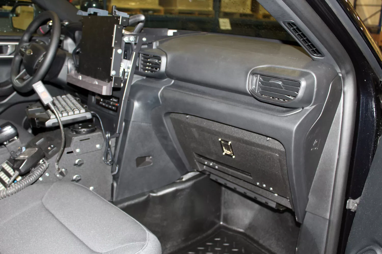 Passenger side of the cruiser dash with the glove box door latched shut and the laptop console alongside