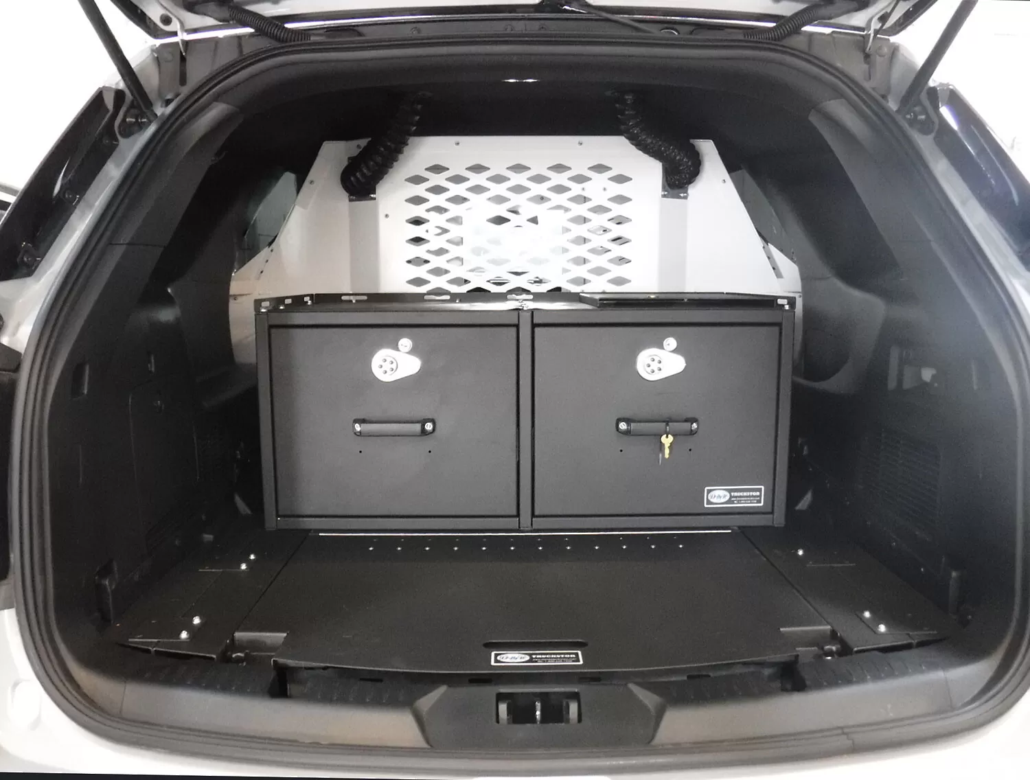 Two black cabinet doors with keyed T-handle locks below the cage, HVAC hoses running up each side