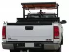 Board folded flat in its stowed position on the rack above the pickup cab, seen over the tailgate