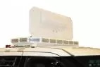 White rear face of the deployed panel standing above the roof-mounted LED bar on a marked SUV
