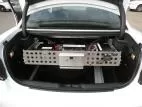 Rear view of the slide-out tray carrying a wired D&R power module and fuse block across the trunk