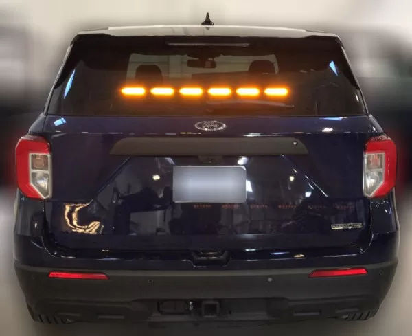 Dark Ford Explorer with all six rear-window modules lit steady amber in a straight line