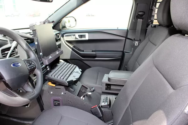 Console installed in a Ford Utility cruiser with laptop keyboard mount and armrest, seen from the passenger door