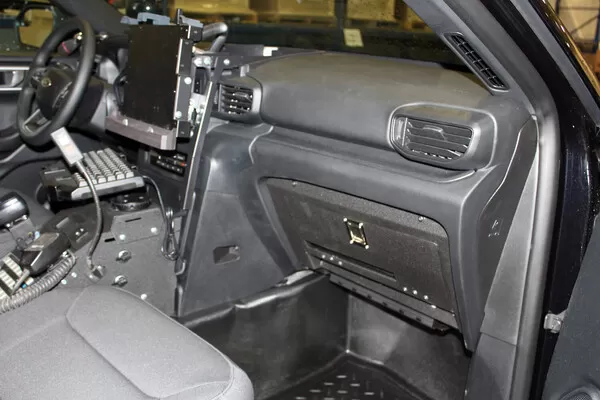 Passenger side of the cruiser dash with the glove box door latched shut and the laptop console alongside