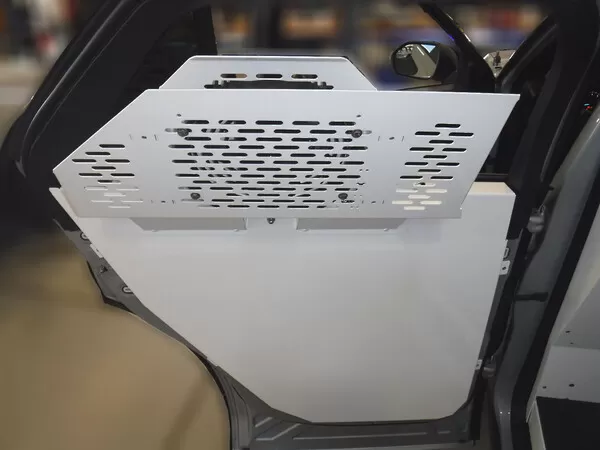 Perforated white door skin panel fitted to the inside of the rear passenger door